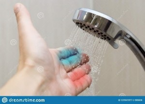 adult hand with showerhead running water onto fingers. The index and middle finger are coloured blue, the fourth and fifth finger are coloured red.