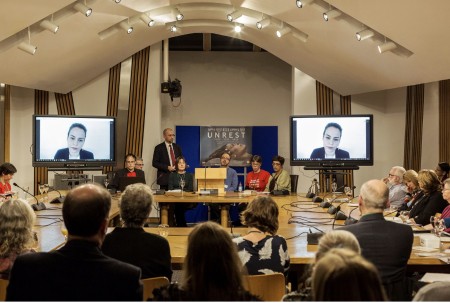 Image shows people attending a film screening of Unrest at the Scottish Parliament. 